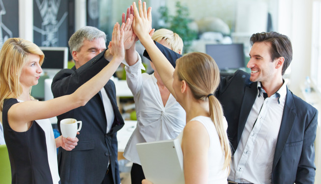 Business Team macht High Five im Büro coaching